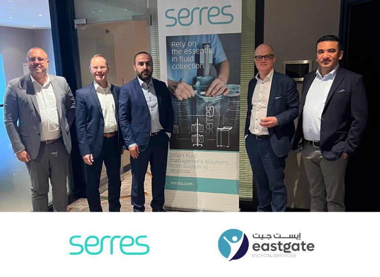 Representatives of Serres and Eastgate Medical Services in front of a Serres rollup.